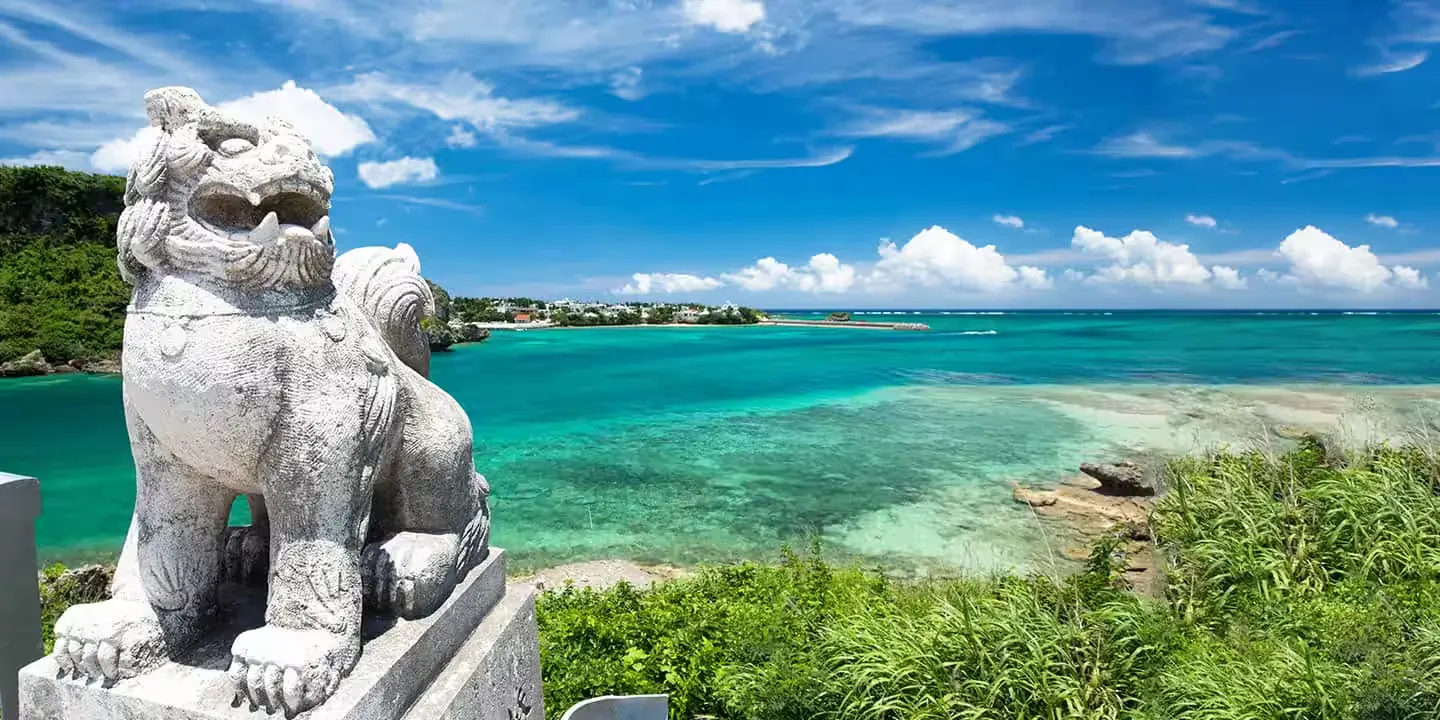 A shisa statue above a turquoise Okinawa bay